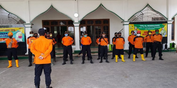 Relawan Tisaga Buana, Karanganyar, memperoleh arahan sebelum melakukan penyemprotan cairan disinfektan (8/10).