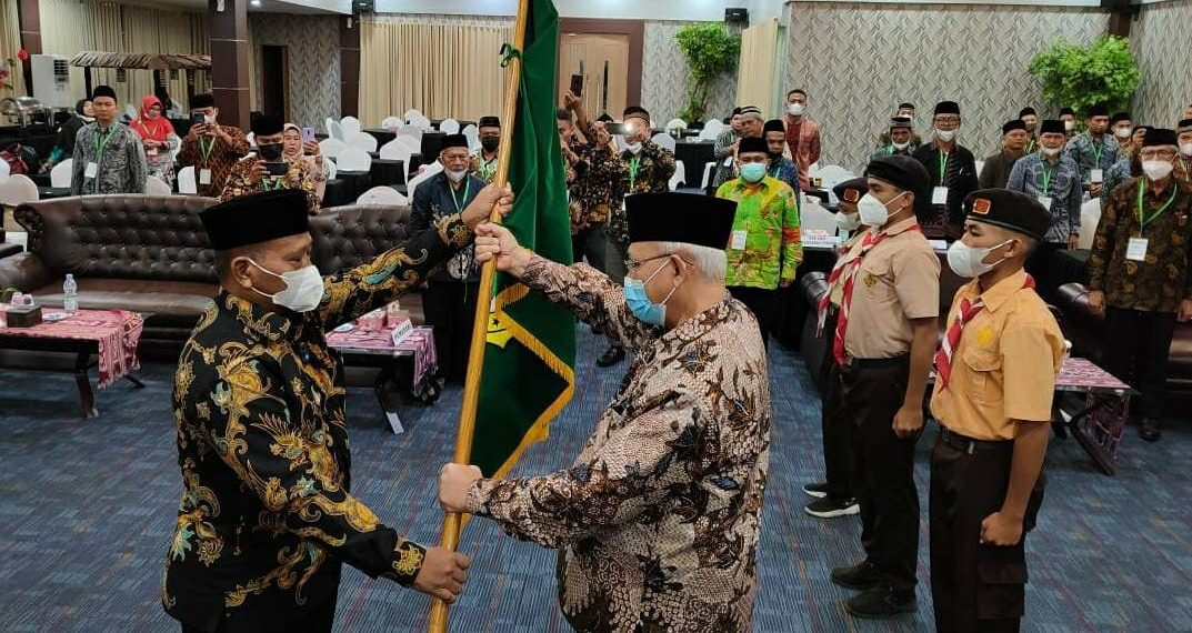 Ketum DPP LDII KH Chriswanto Santoso menyerahkan pataka simbolis kepada Ketua Terpilih LDII Maluku Utara, Nurhadi. Foto: LINES.