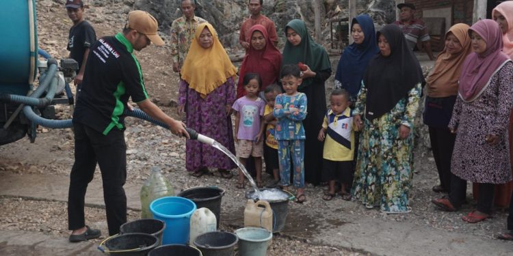 Relawan LDII menyalurkan selang bantuan air bersih kepada warga yang membutuhkan. Foto: LINES.
