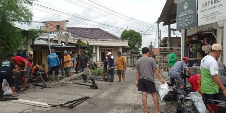 Warga Desa Karang Rahayu bersama PAC LDII Karang Rahayu melaksanakan kerja bakti untuk membersihkan saluran air di sepanjang jalan desa yang menghubungkan Desa Sukaraya dan Karang Rahayu. Foto: LINES.