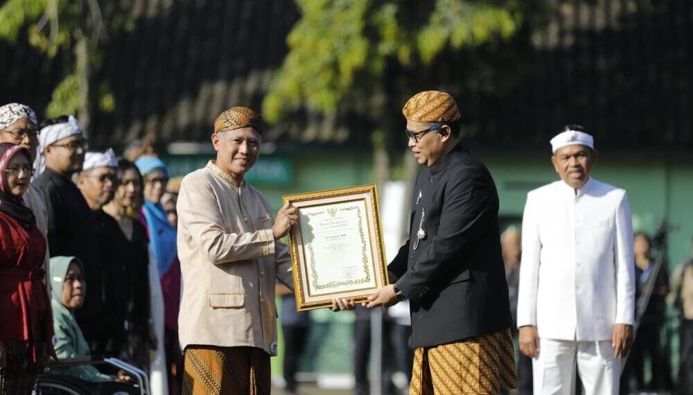 Agus Purwanto, warga LDII Karawang yang mengajar di SMA Budi Mulia, Karawang, Jawa Barat menerima penghargaan saat Hardiknas. Foto: LINES.
