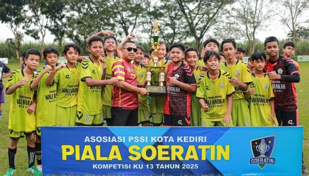Putra Utama Wali Barokah mengangkat trofi juara Piala Soeratin U-13 Kota Kediri tahun 2025. Foto: LINES.