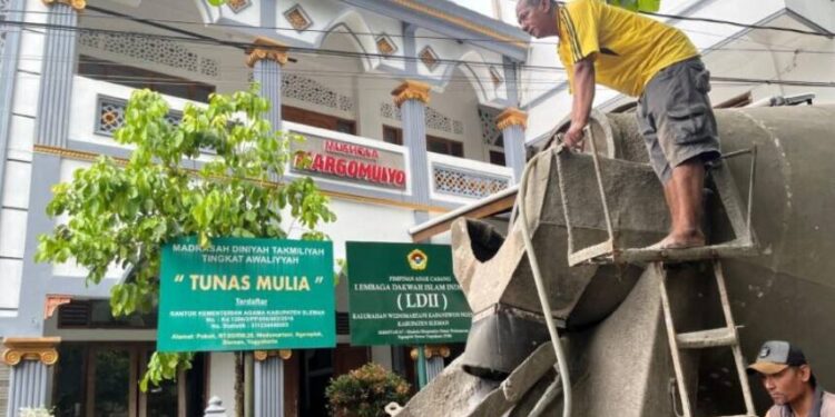 PC LDII Ngemplak bersama warga Dusun Pokoh, Wedomartani, melaksanakan pengecoran jalan lingkungan. Foto: LINES.
