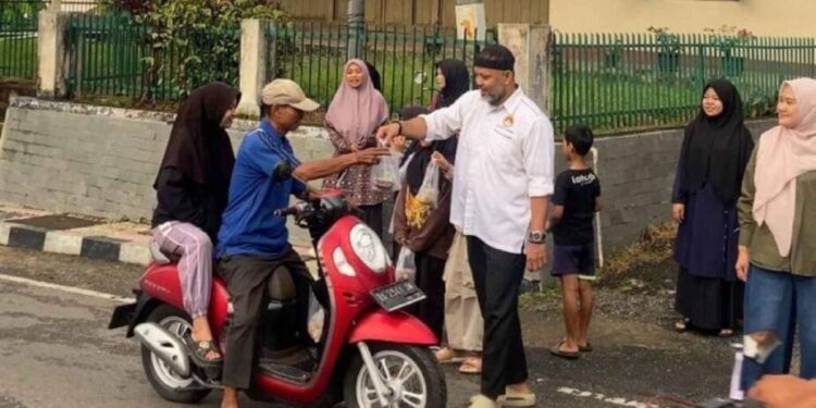 Ketua DPD LDII Kota Sawahlunto H. Dedy Salman membagikan takjil kepada pengendara motor. Foto: LINES.