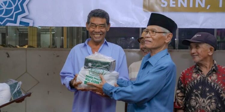 Ketua Ponpes Wali Barokah, KH Sunarto saat mendampingi pembagian sembako ke warga sekitar. Foto: LINES.