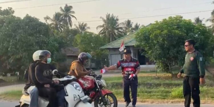 Dewan Komando Wilayah (DKW) Panji Bangsa Kalbar dan perwakilan mahasiswa membagikan bendera merah putih yang juga dihadiri pengurus LDII Kalimantan Barat. Foto: LINES.